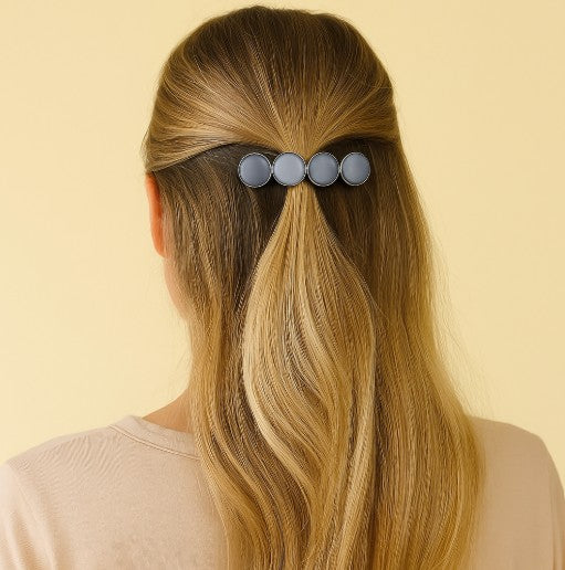 Model met lang blond haar draagt grijze Haarspeld Color Hairclip XL voor een elegante en stevige look
