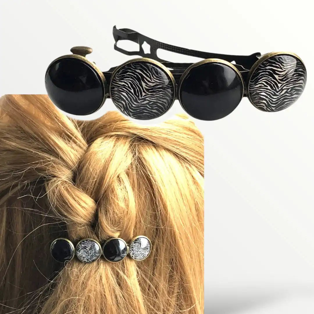 Een haarspeld met vier knoppen, afwisselend in effen zwart en zebra-print ontwerpen