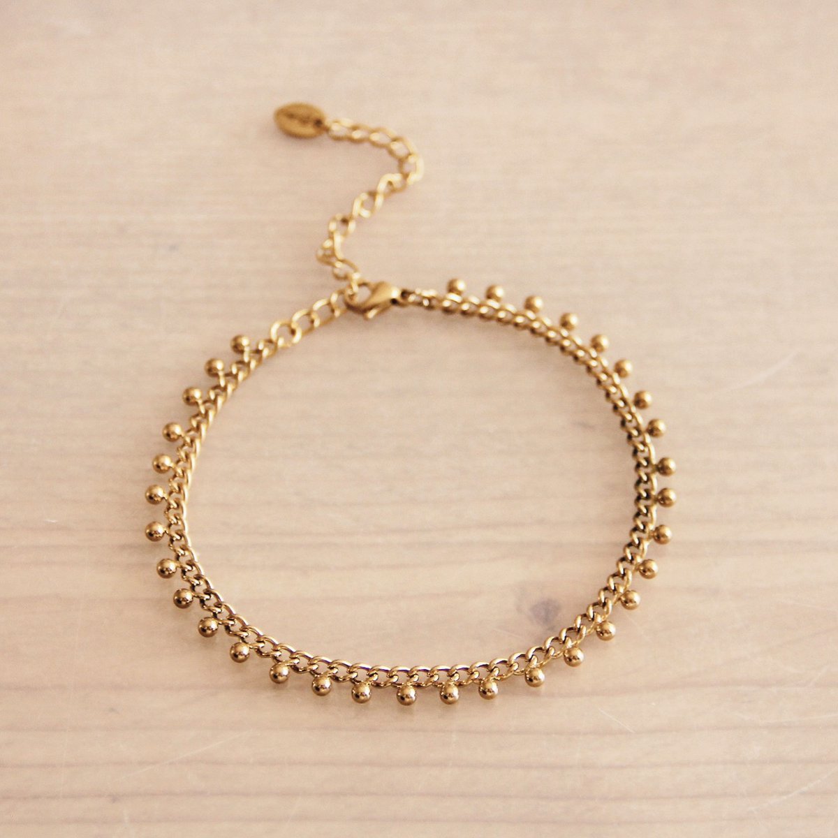SA834: Stalen schakelarmband met balletjes - goud