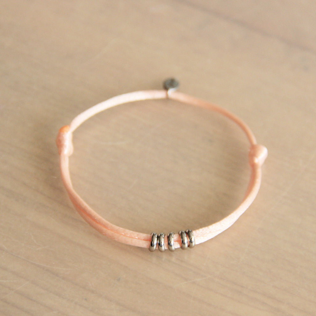 LC127: Satijnen armband met ringen – perzik/zilver